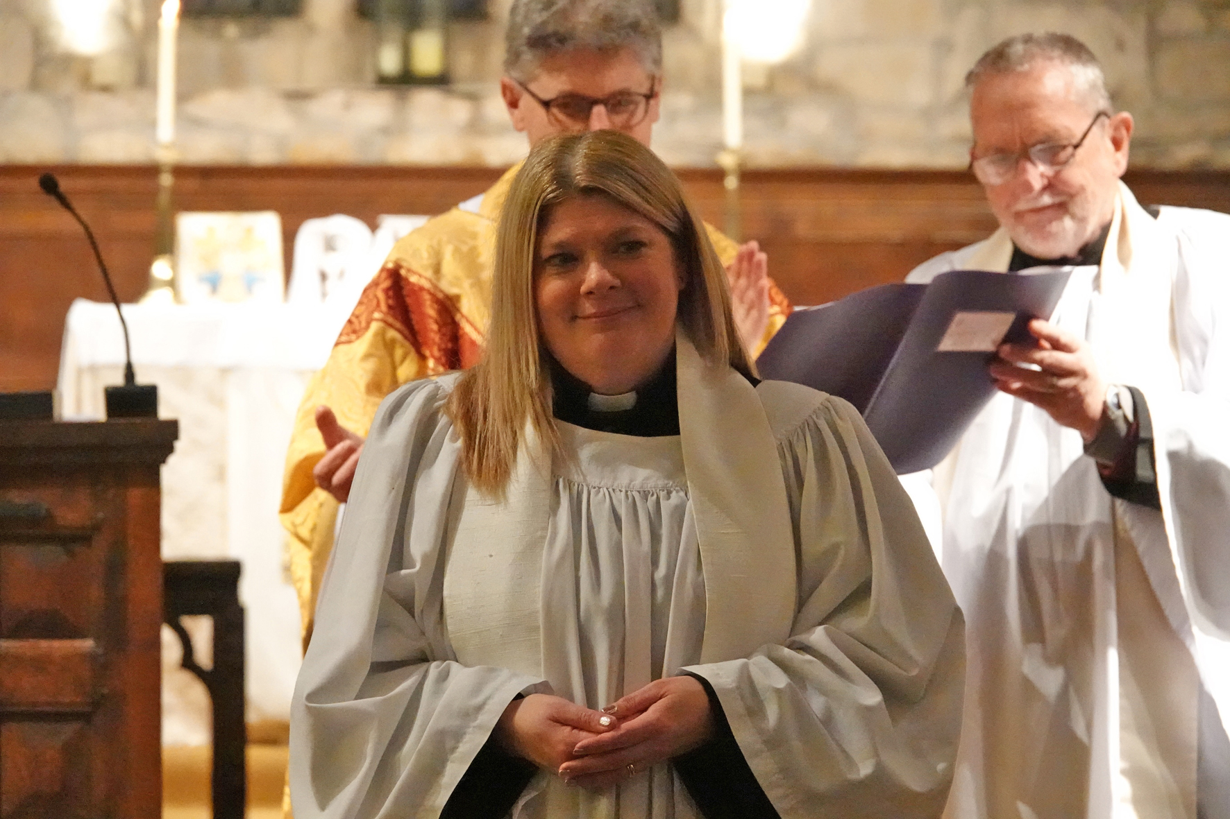 Sooz Magee standing in front of Bishop Martin smiling after her ordination