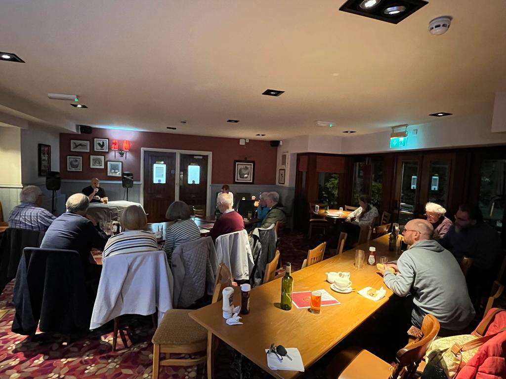 People sat at tables at the pub at the Gill a Vicar night.