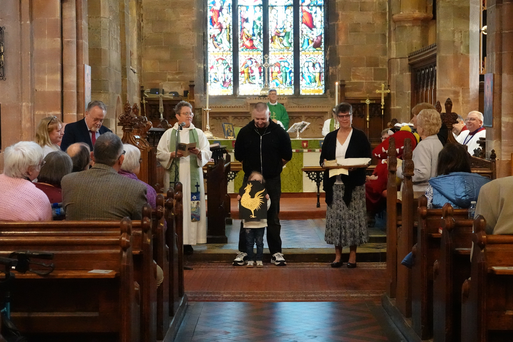 People stood at the front of St John's Church holding objects representing their different churches