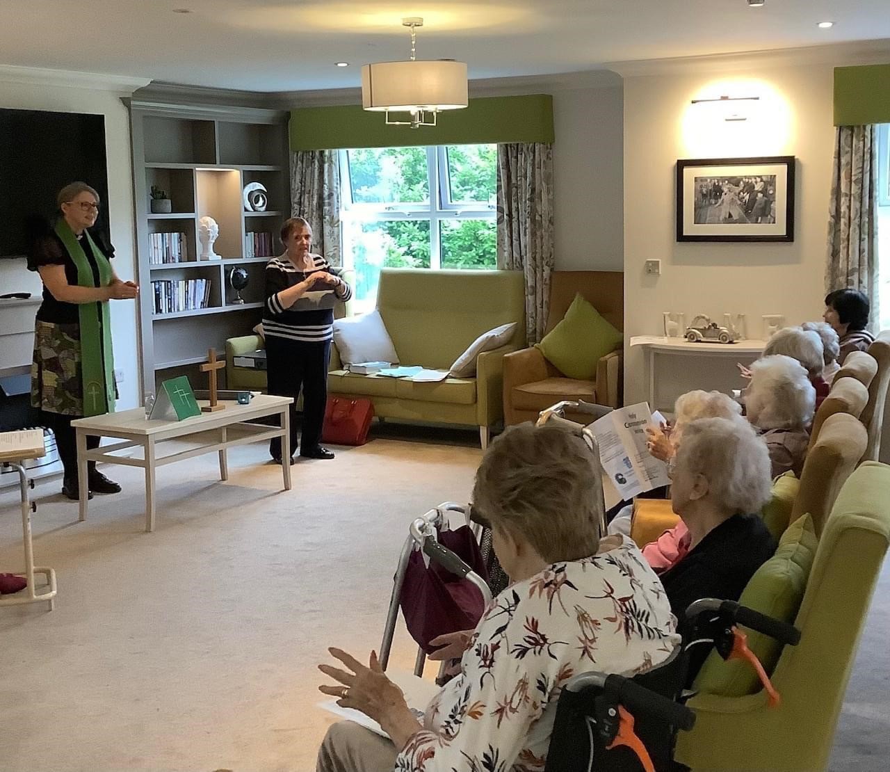 Mel Beynon stands in front of a group of residents of a local care home to lead worship