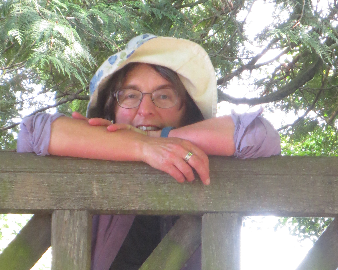 Anthea Elston leaning on a lychgate