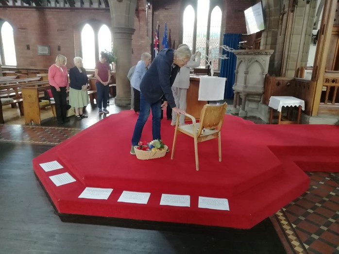 Lady offering a prayer at a prayer station at the front of St Barnabas church