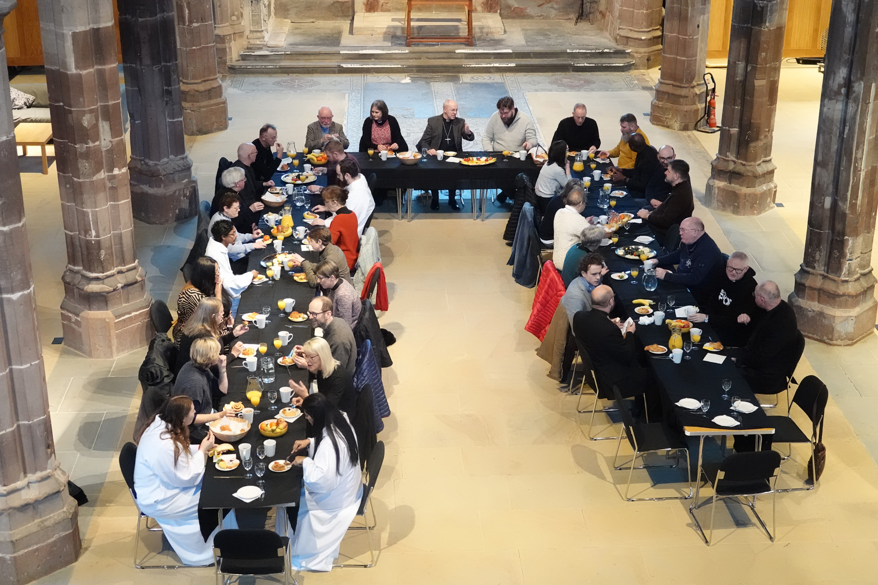 Arial view of people sat around long tables in St Helen's Church eating breakfast