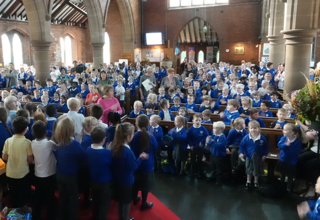 St Barnabas church full of children celebrating their harvest festival