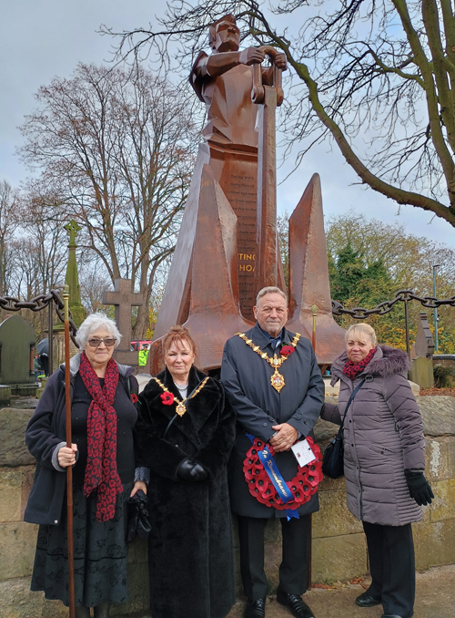 Four people, two in mayoral chains standing in front of the new memorial