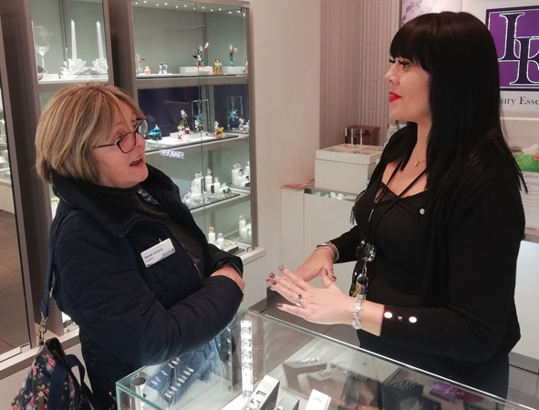 Faith at work volunteer talking to a lady in a shop