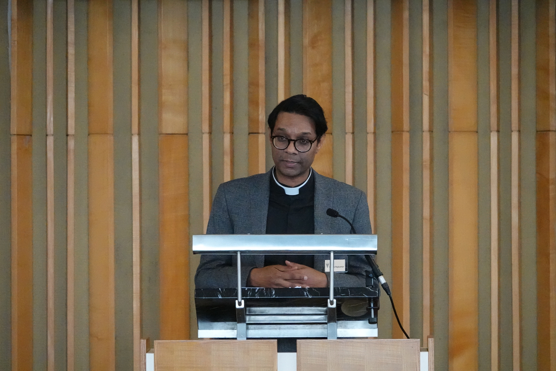 Peniel Rajkumar standing at a podium