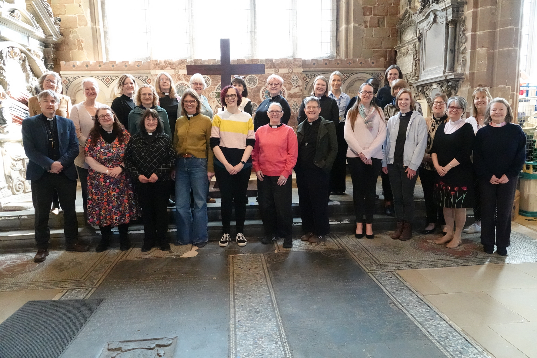 A group of female clergy standing together in St Helen's Church with Bishop Hugh