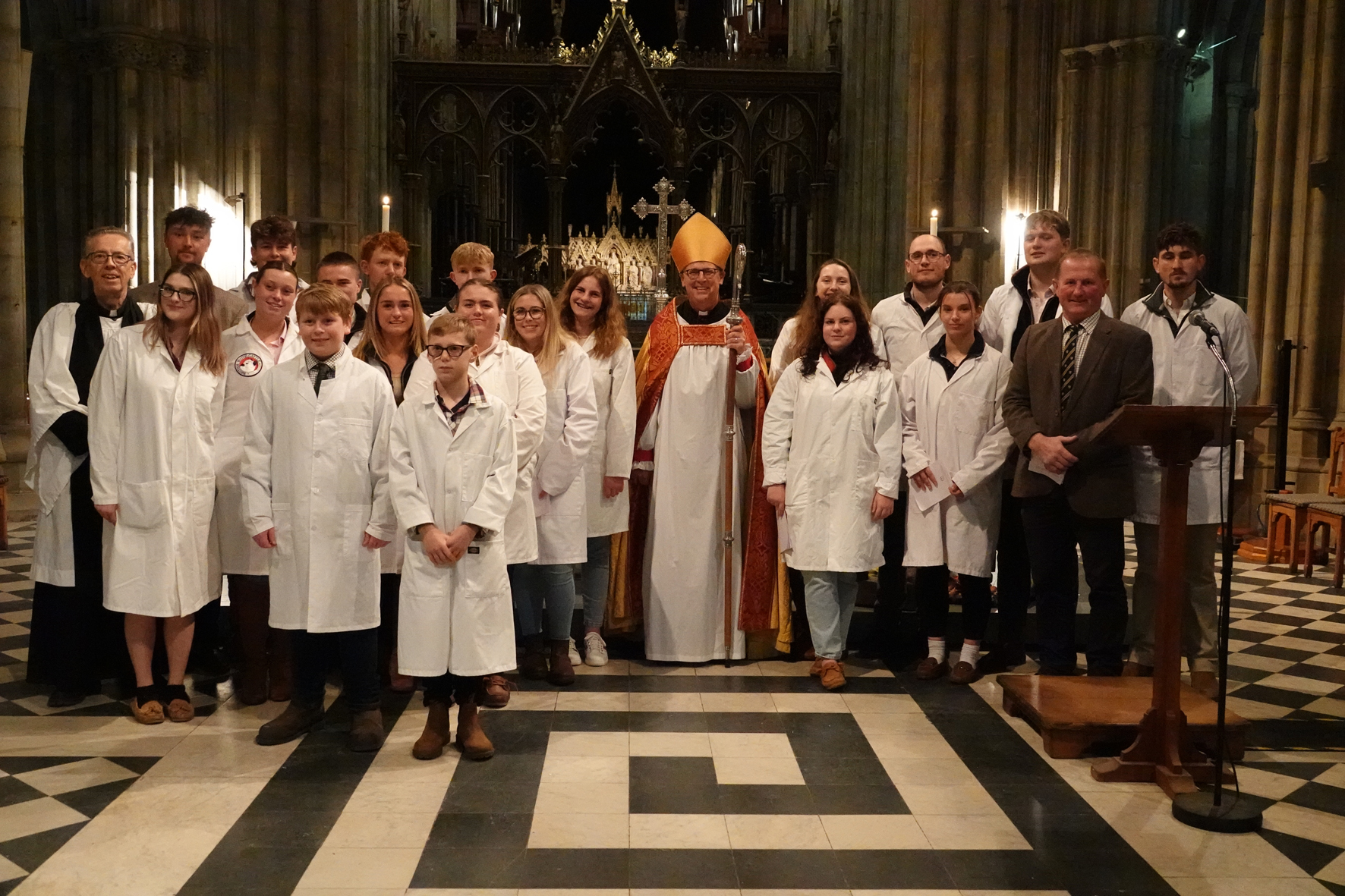 Young farmers standing with Bishop Martin in front of the altar in the Cathedral