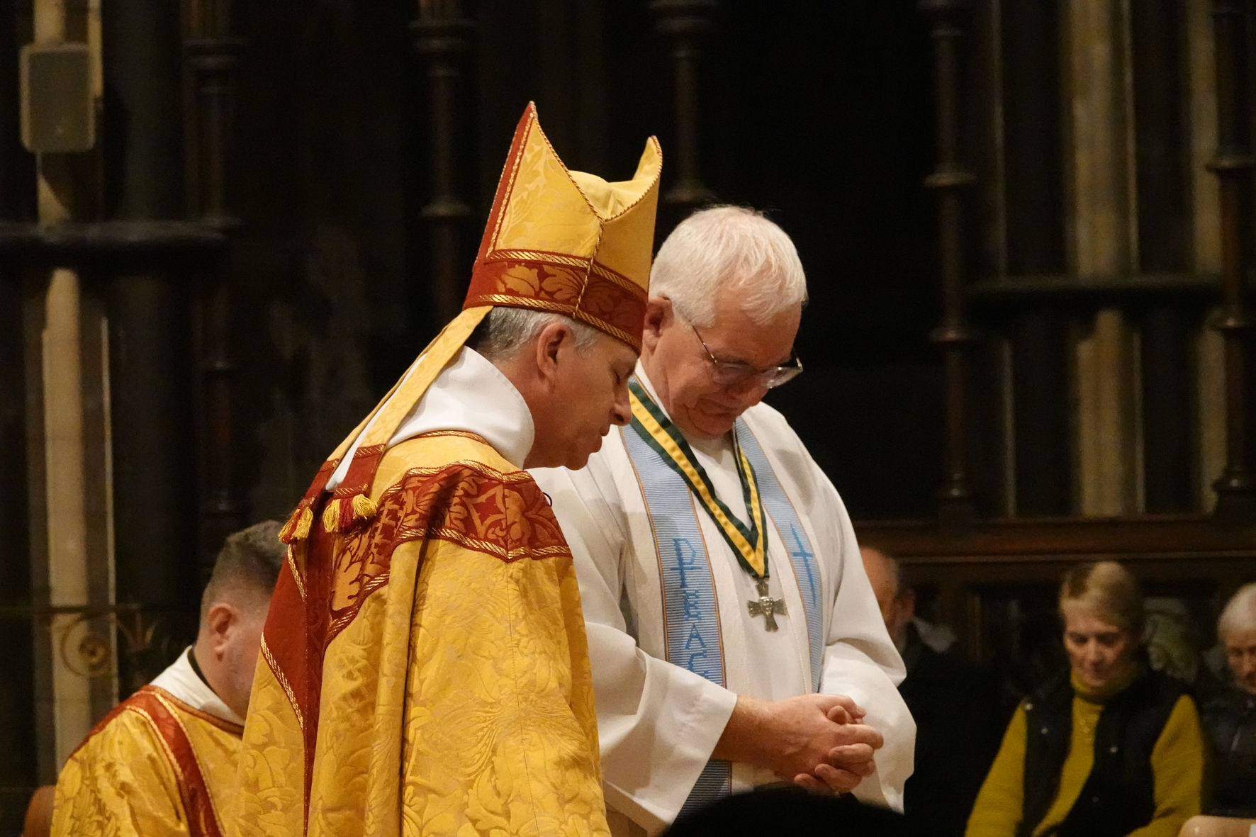 Bishop Hugh praying for Dick Johnson after awarding him the Wulfstan Cross