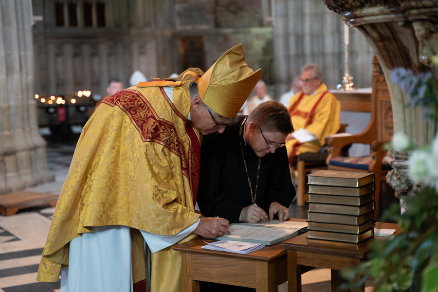 Bishop Martin and Bishop Bettina sign a new partnership agreement on a table at the front of the Cathedral
