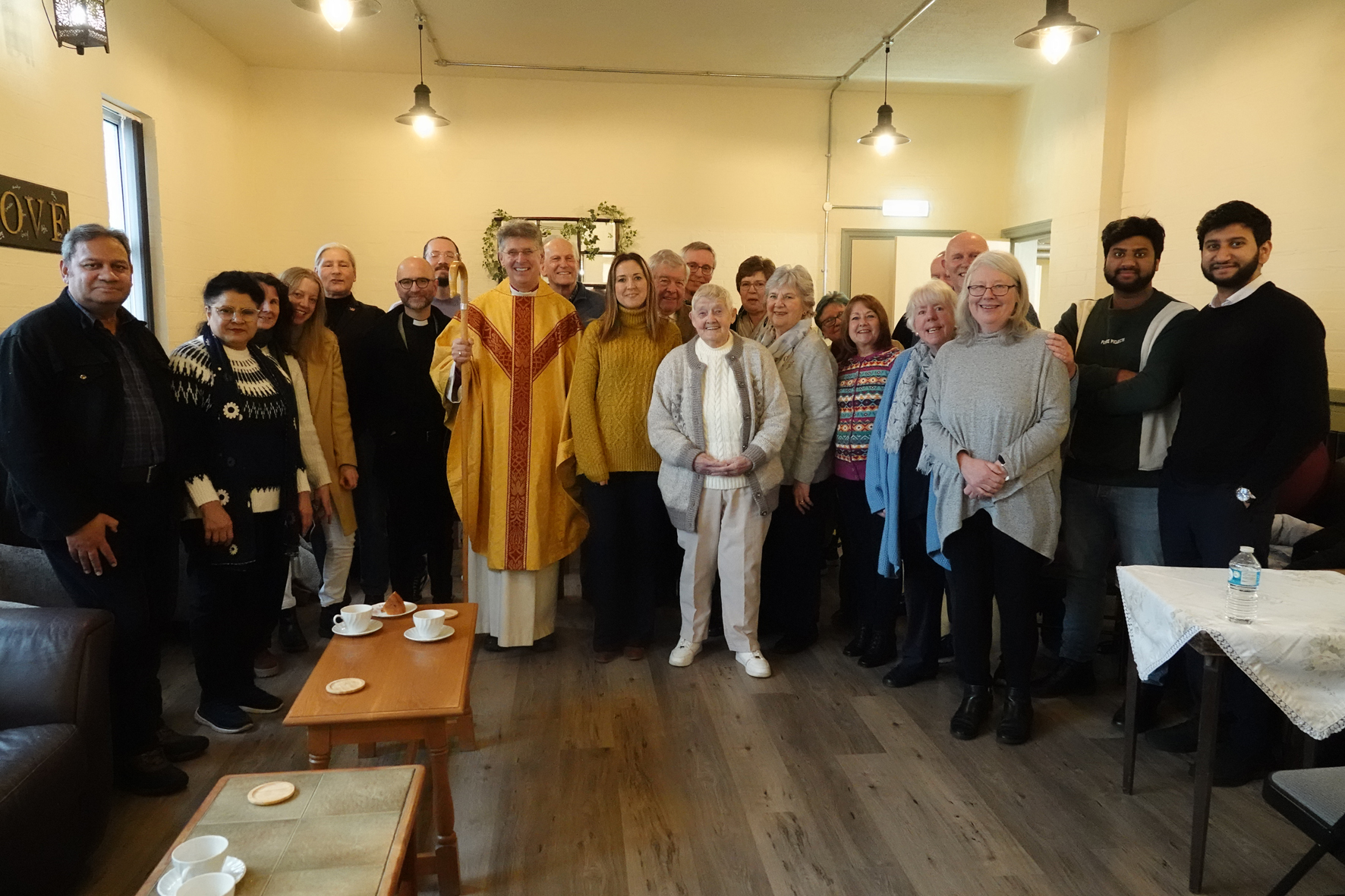 Bishop Martin standing with the congregation of St John's Church in their community hub