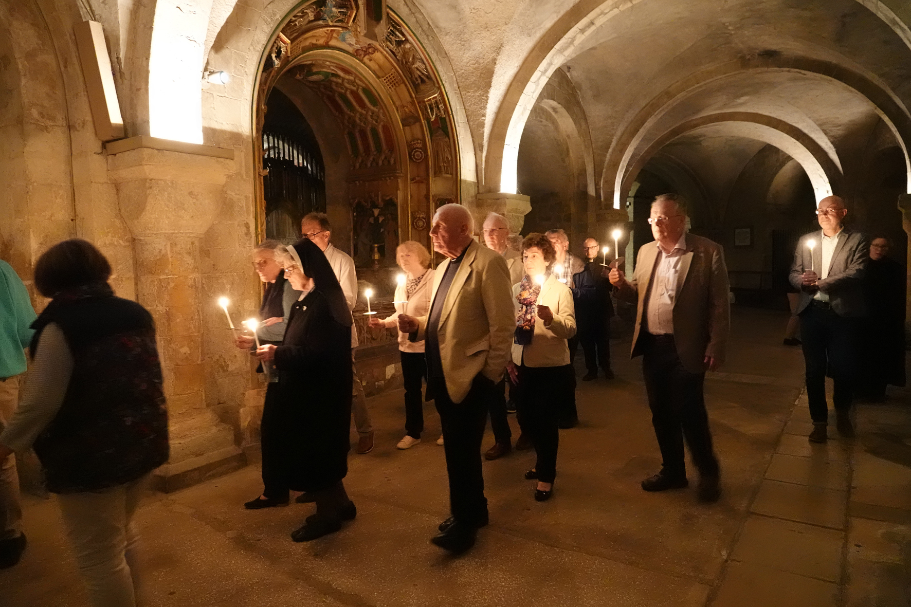 pilgrims walking through the Cathedral crypt in candlelight