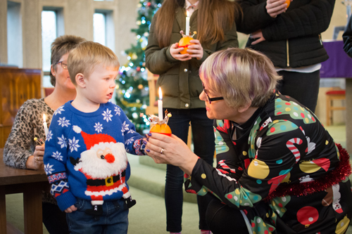 child receiving a christingle from Hazel Charlton