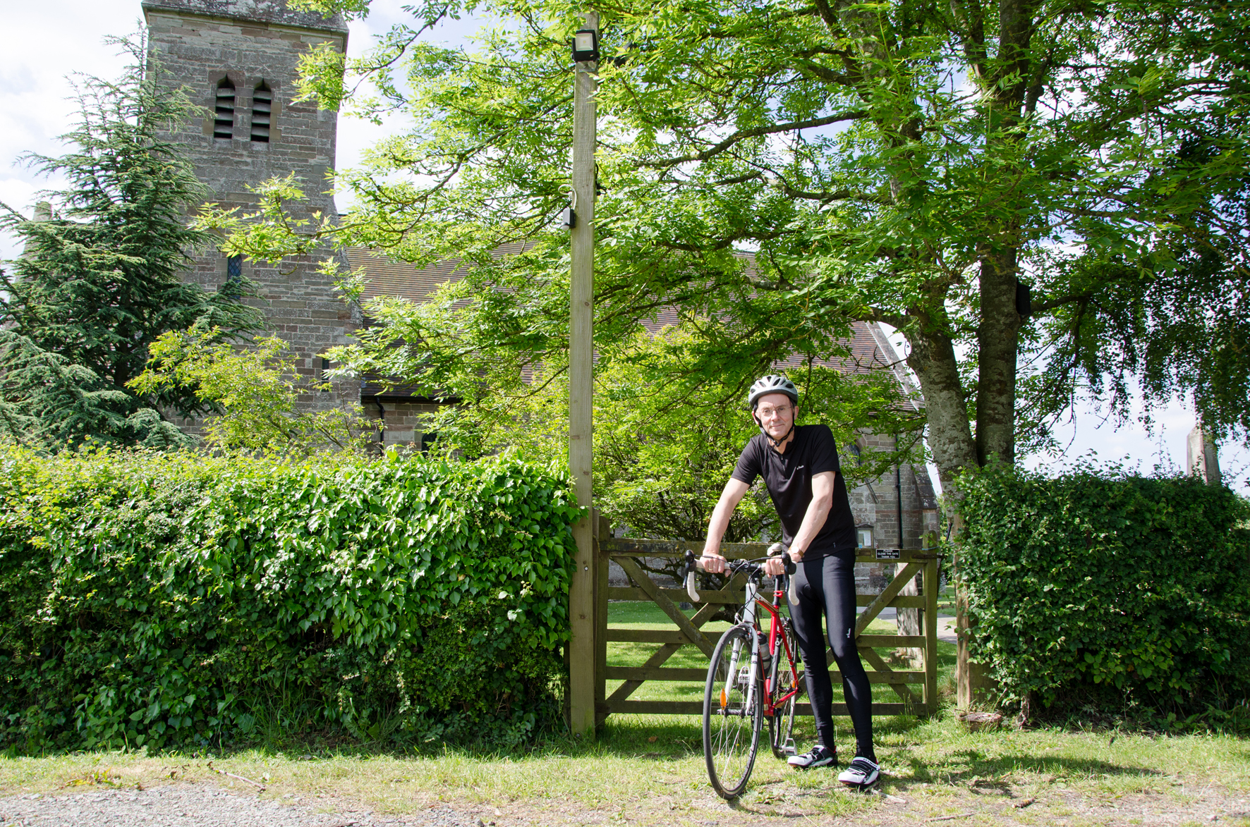 Bishop John on his bike outside St John the Baptist, Stock & Bradley