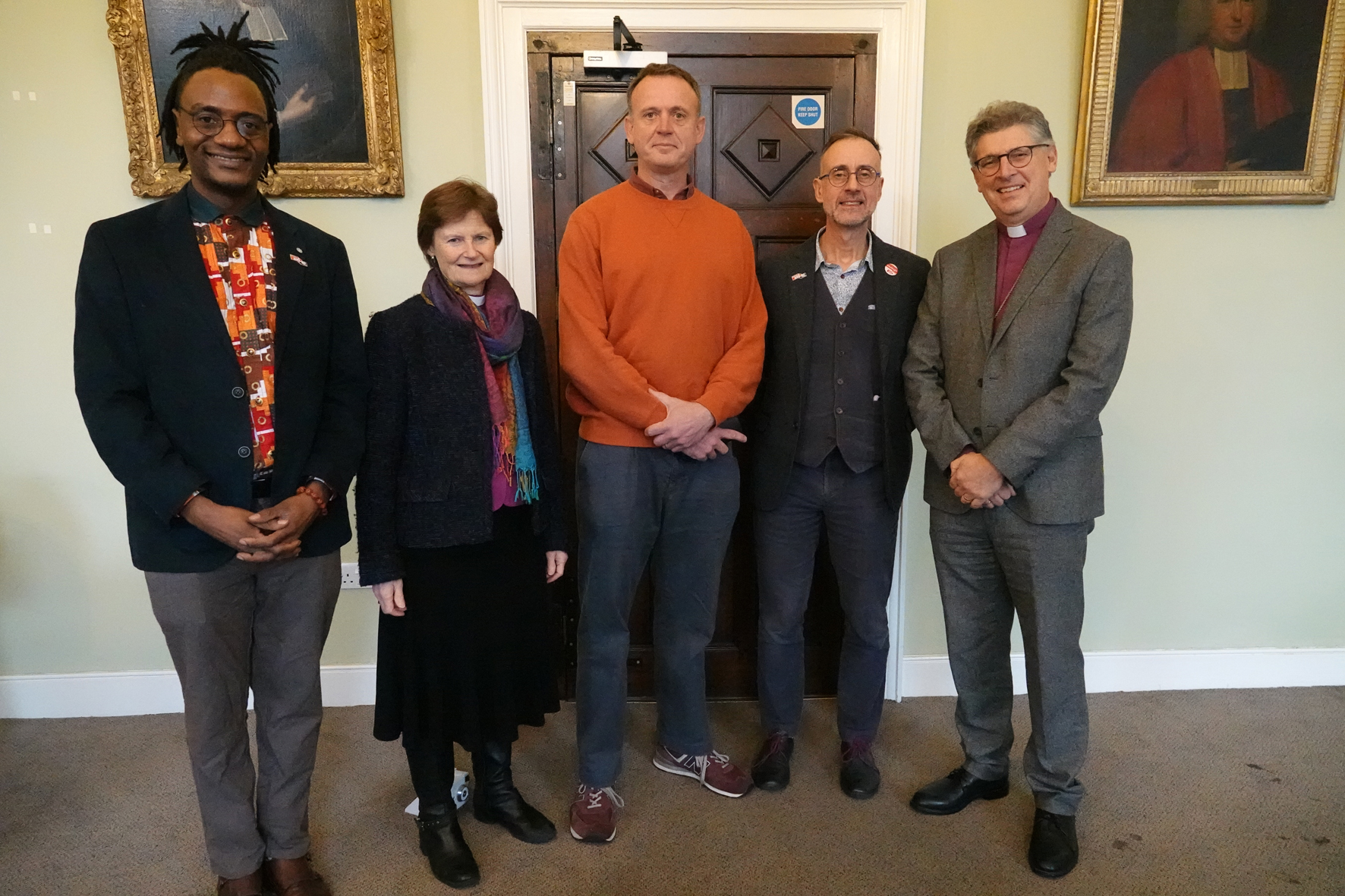CEO of Christian Aid, Patrick Watt stands in the middle of local activists, Bishop Olivia and Bishop Martin