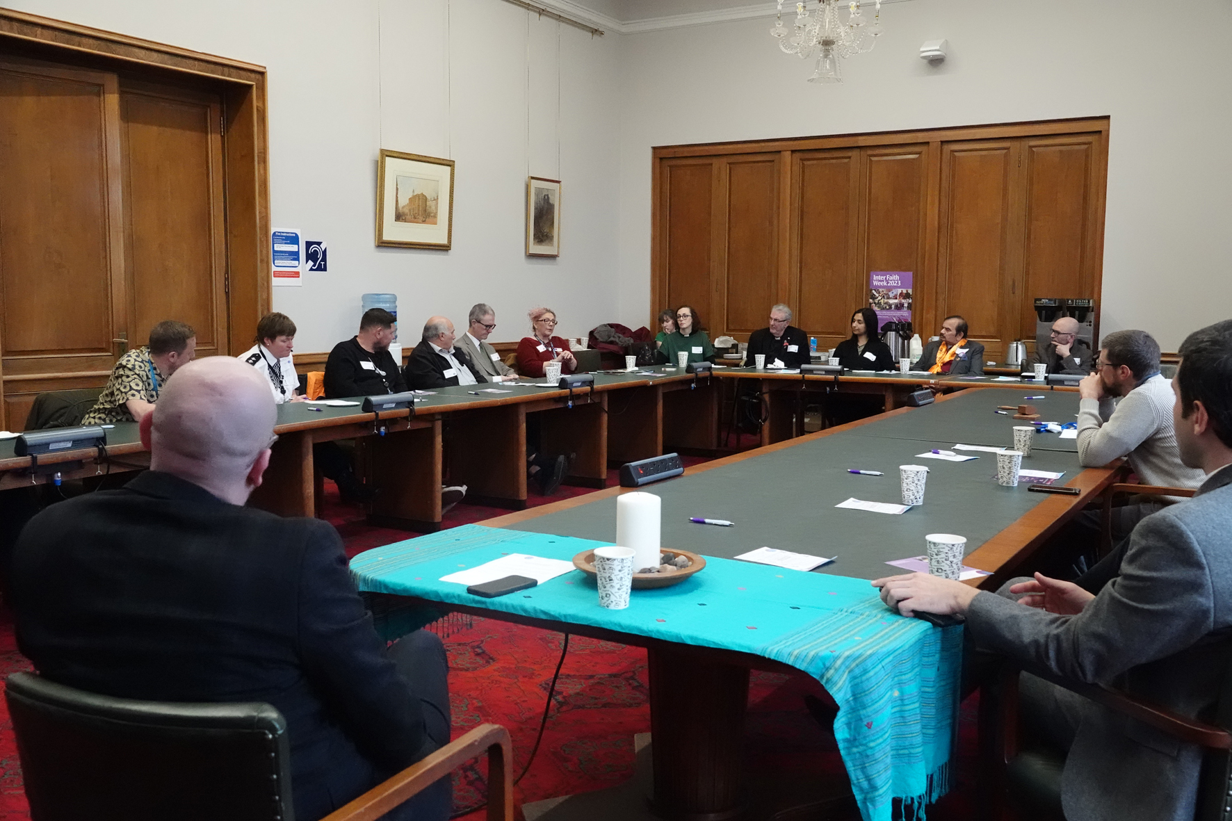 People sitting around a table at the interfaith week reception