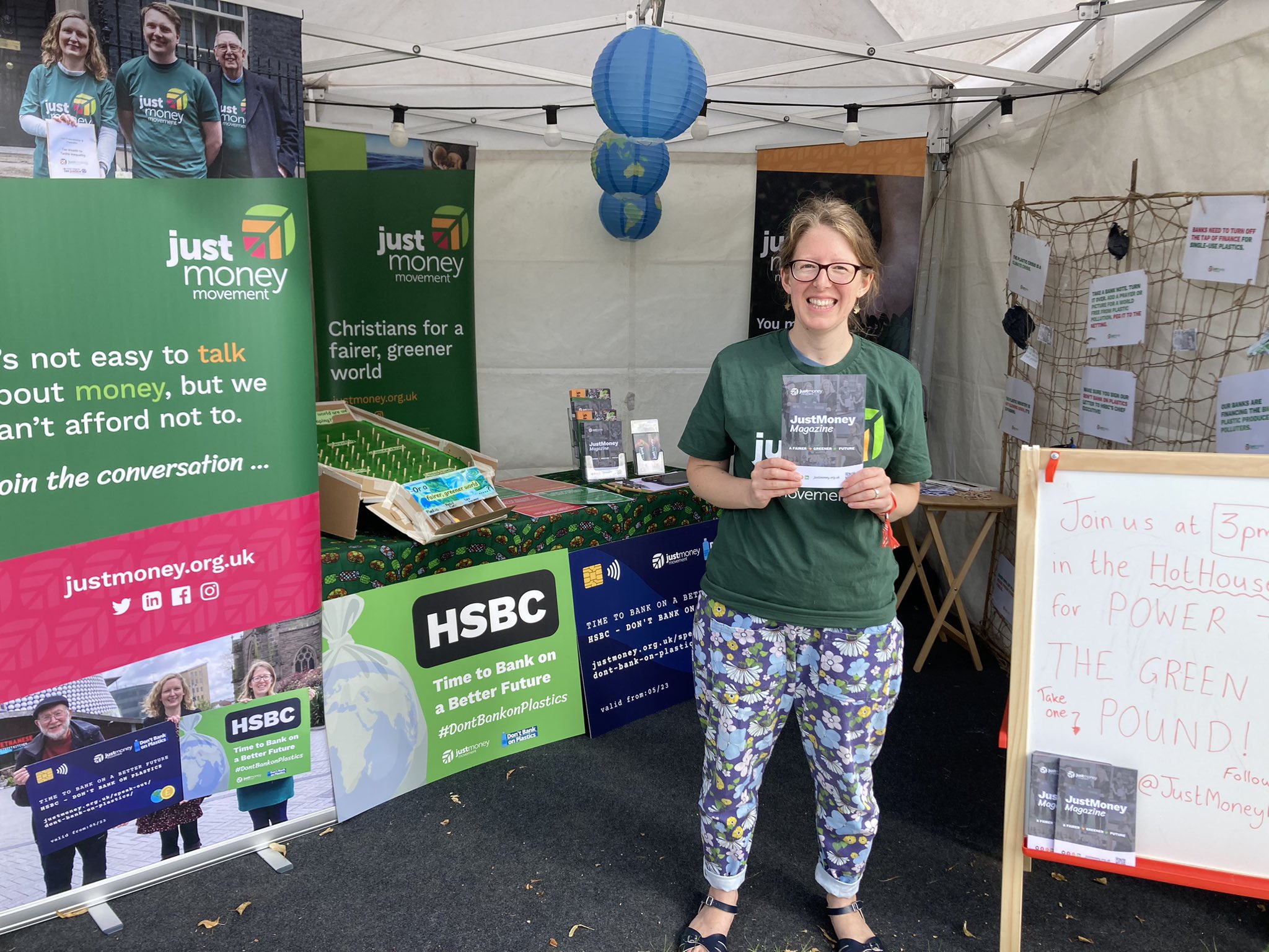 Rosie standing holding a leaflet on the JustMoney stall at Greenbelt