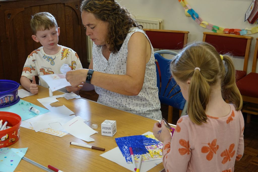 Youth worker helping two children