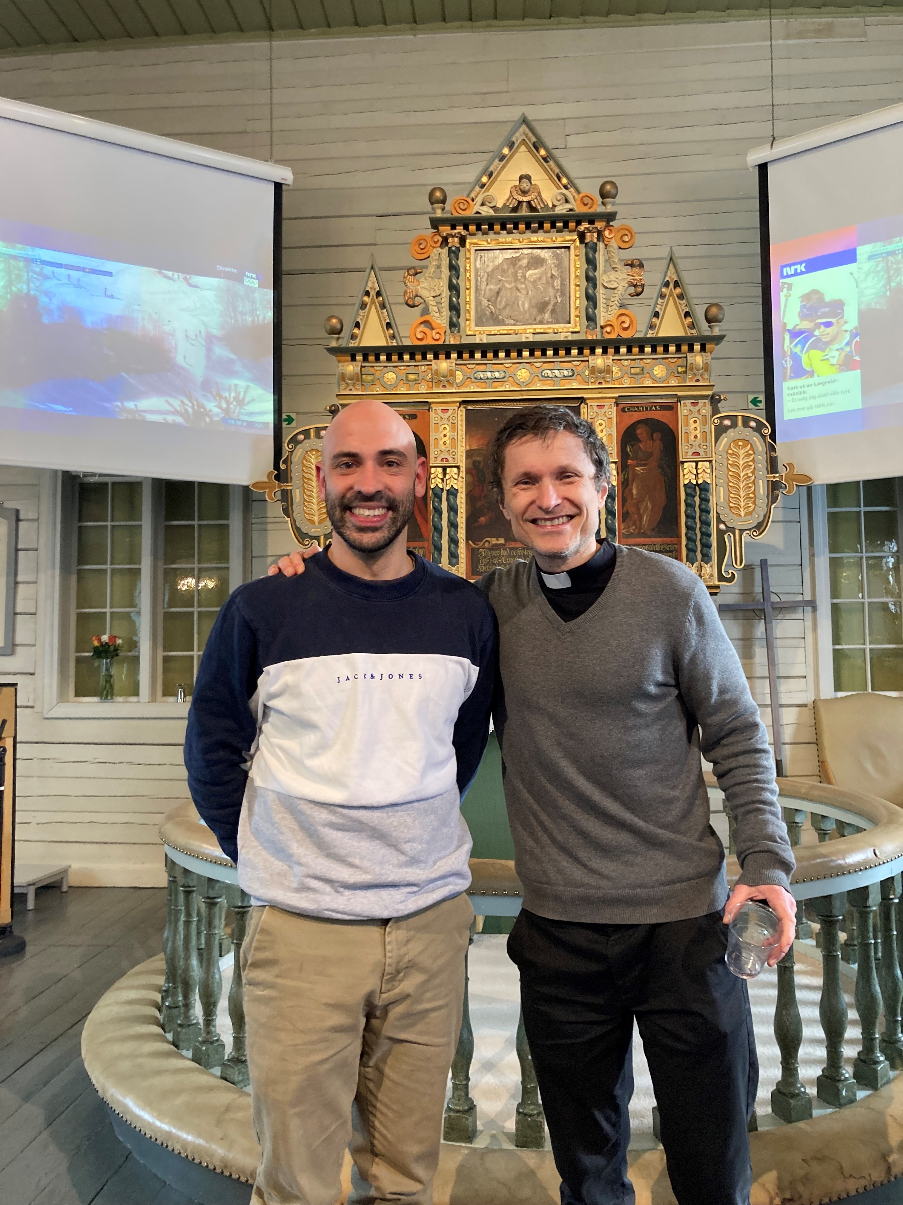 Jamie Klair standing next to Priest Justus at his church in Norway
