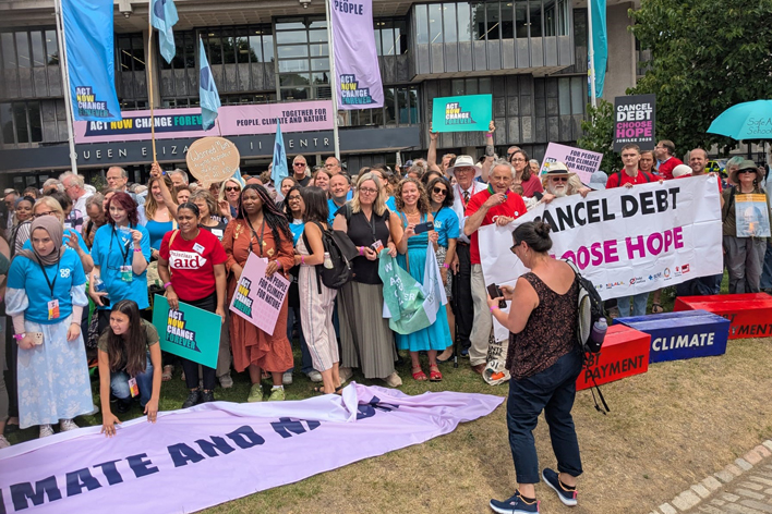 A group of people standing together  holding banners as part of the Mass climate lobby.