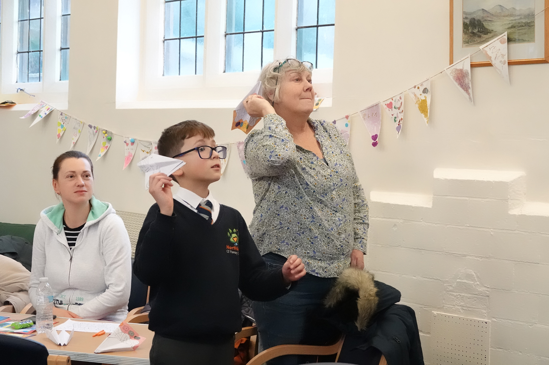 Boy and leader about to throw paper aeroplanes at the Malvern Link after school club