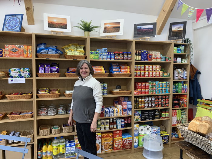 Revd Kim Topham standing in front of shelves of groceries inside Clent Connect
