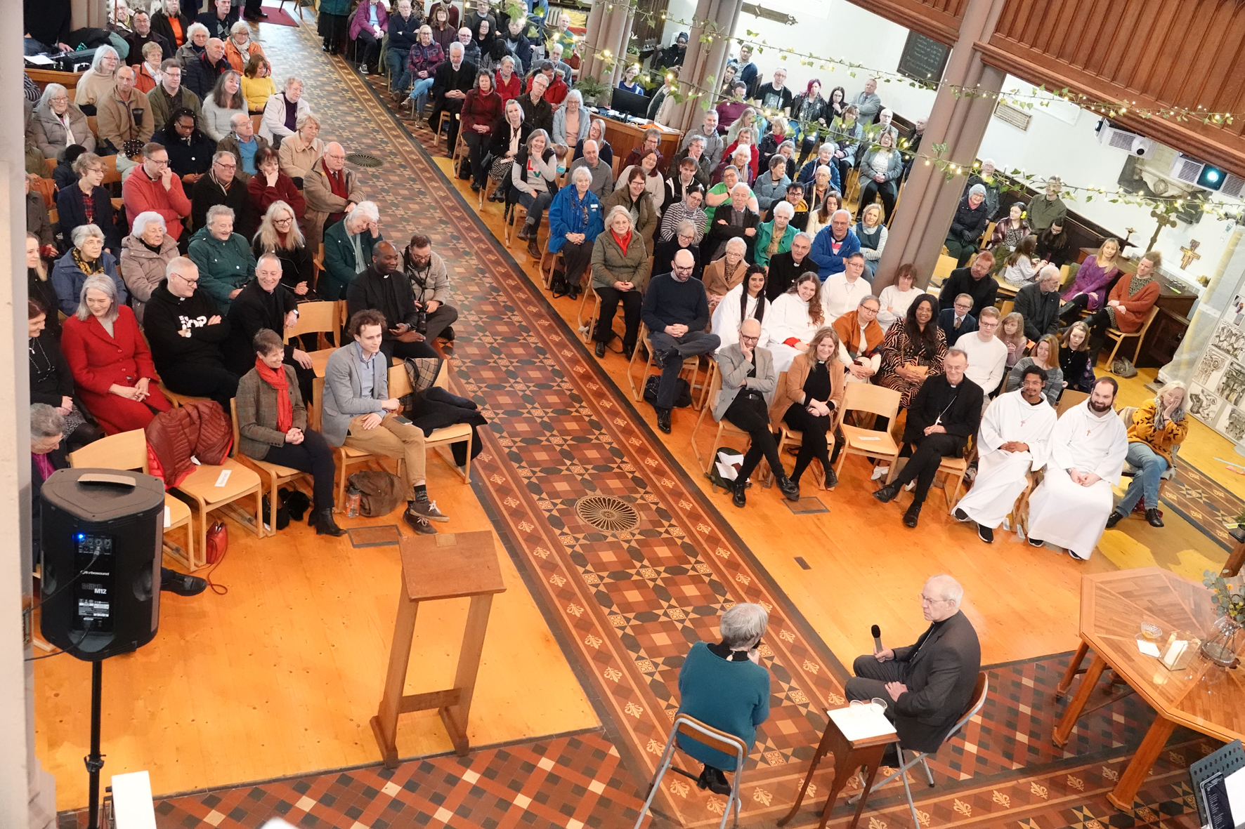 Archdeacon Nikki interviewing Archbishop Justin at the front of a packed Top Church