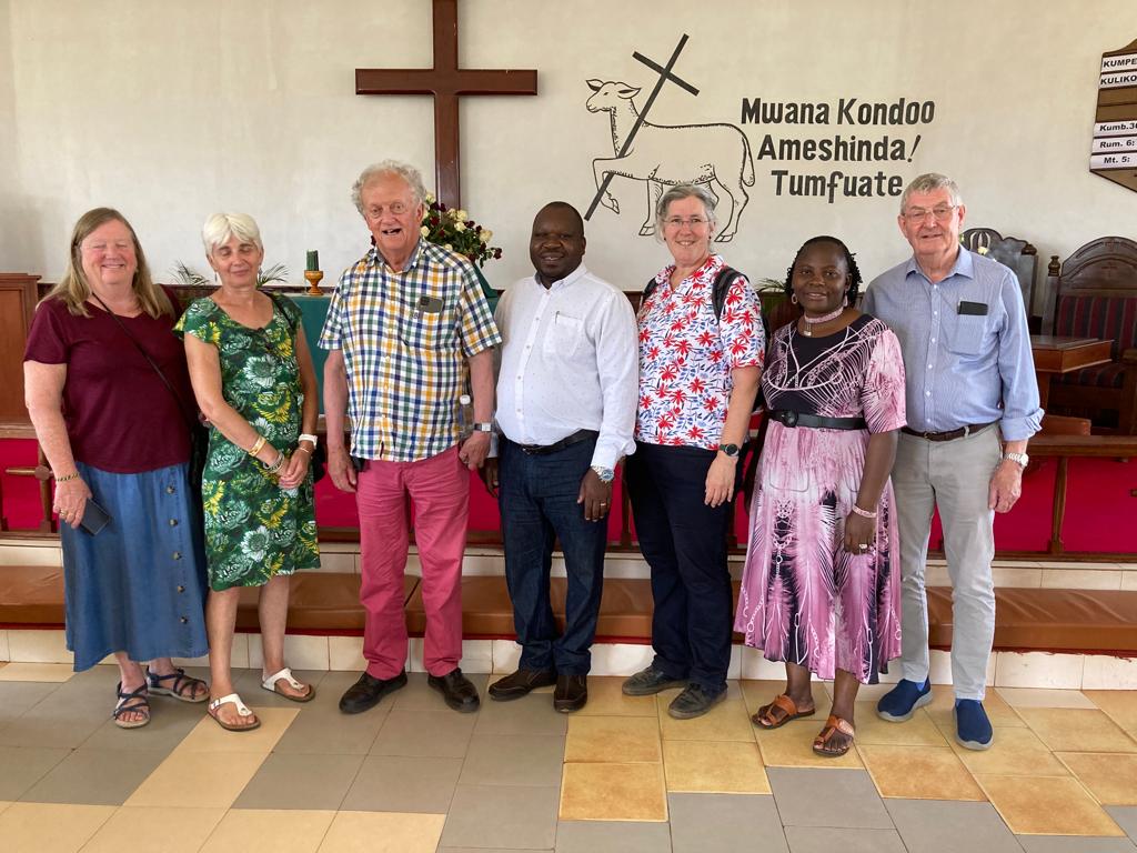 The visitors to Morogoro stand in front of a cross