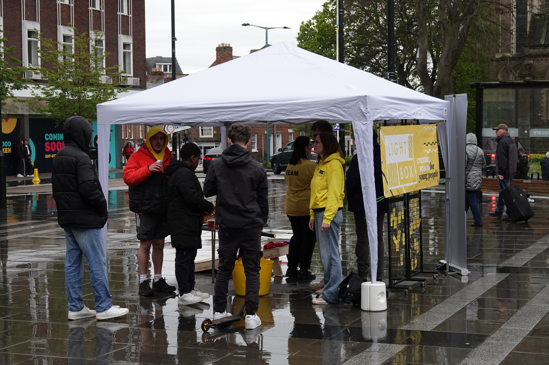 Young People standing at the Lightbox Gazebo talking to volunteers