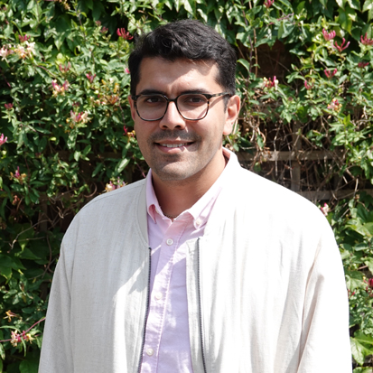 Head and shoulders picture of Joseph stood in front of a green bush