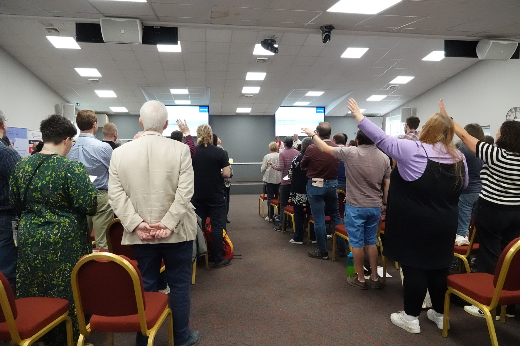Backs of clergy heads as they worship together at their conference