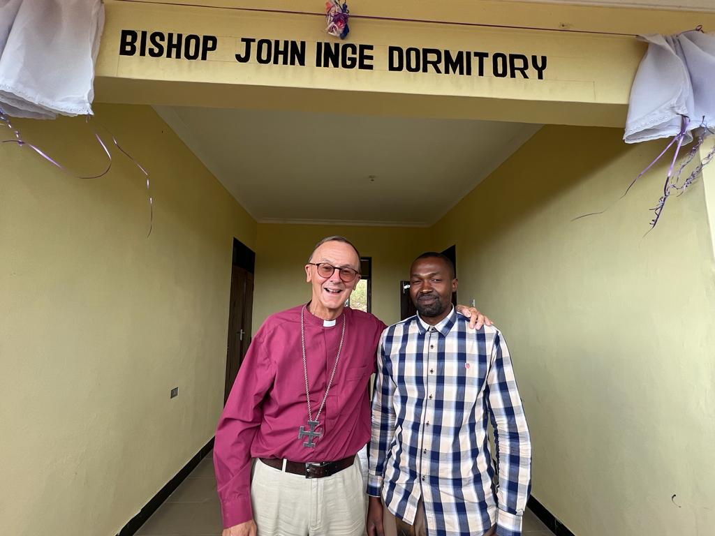 Bishop John standing outside of a dormitory in Morogoro named after him