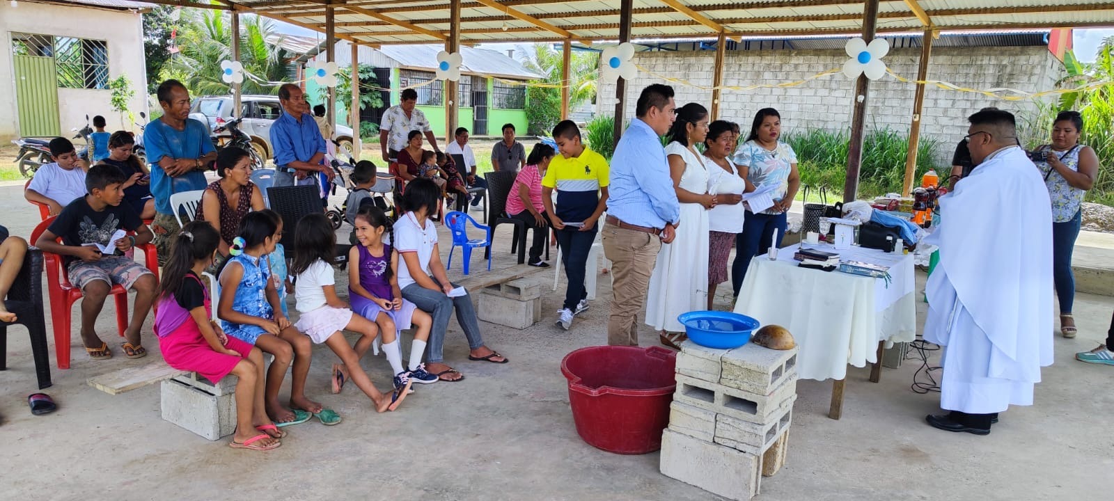 People standing in front of the altar while the congregation watches on in the Mission Church in the Amazon rainforest