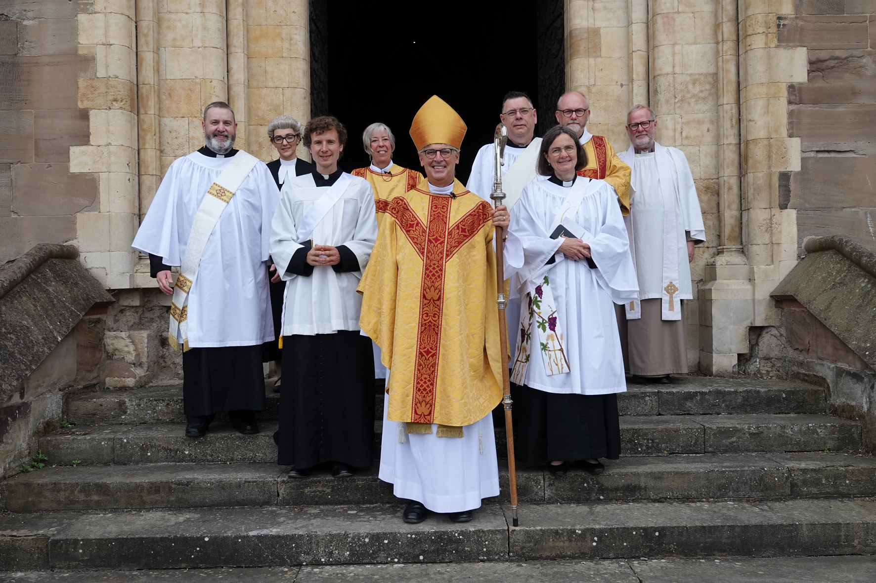 Bishop Martin standing with the deacons outside the west door of the cathedral after their ordination