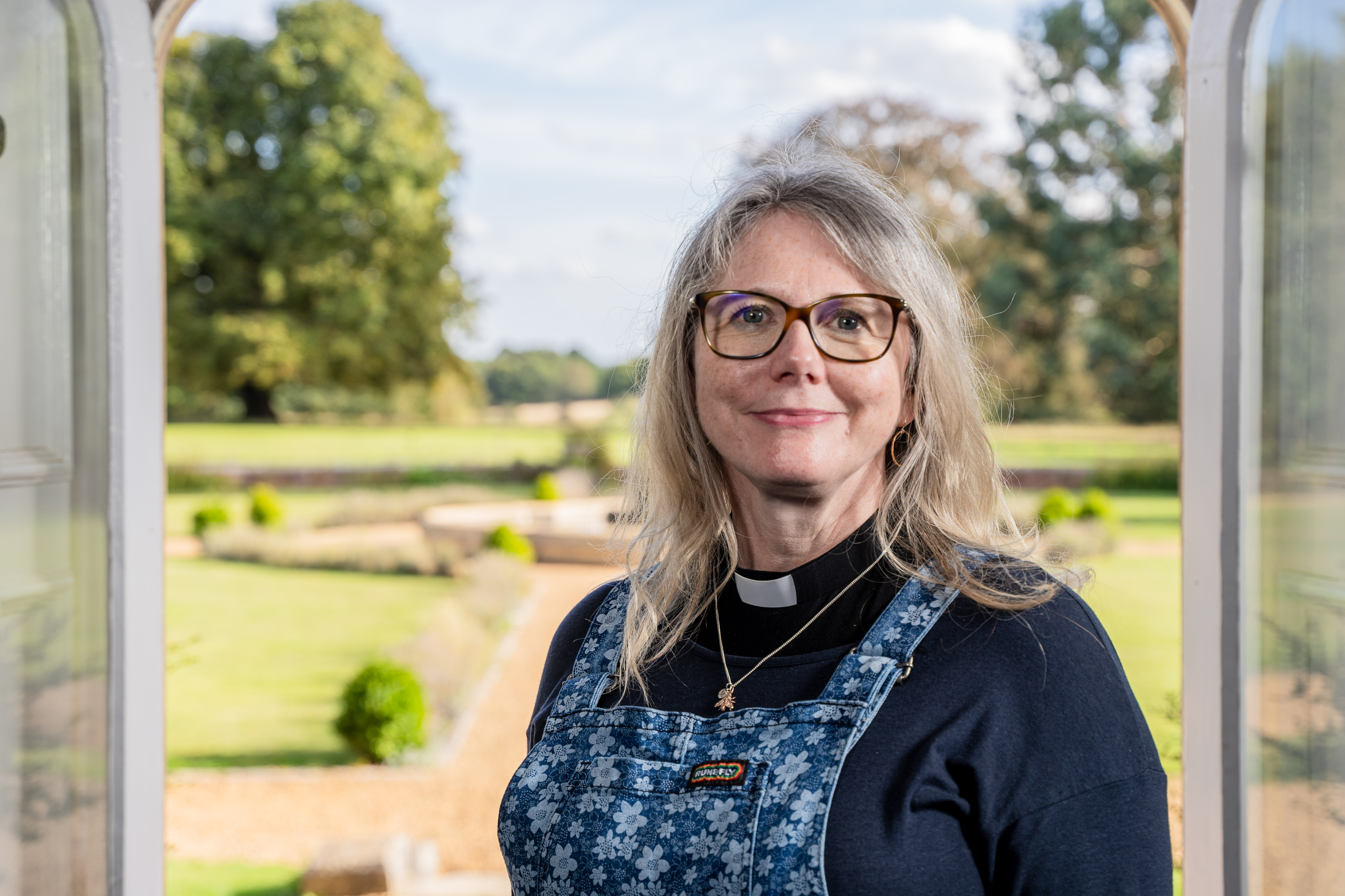 Mel Beynon standing in front of an open door out onto a garden