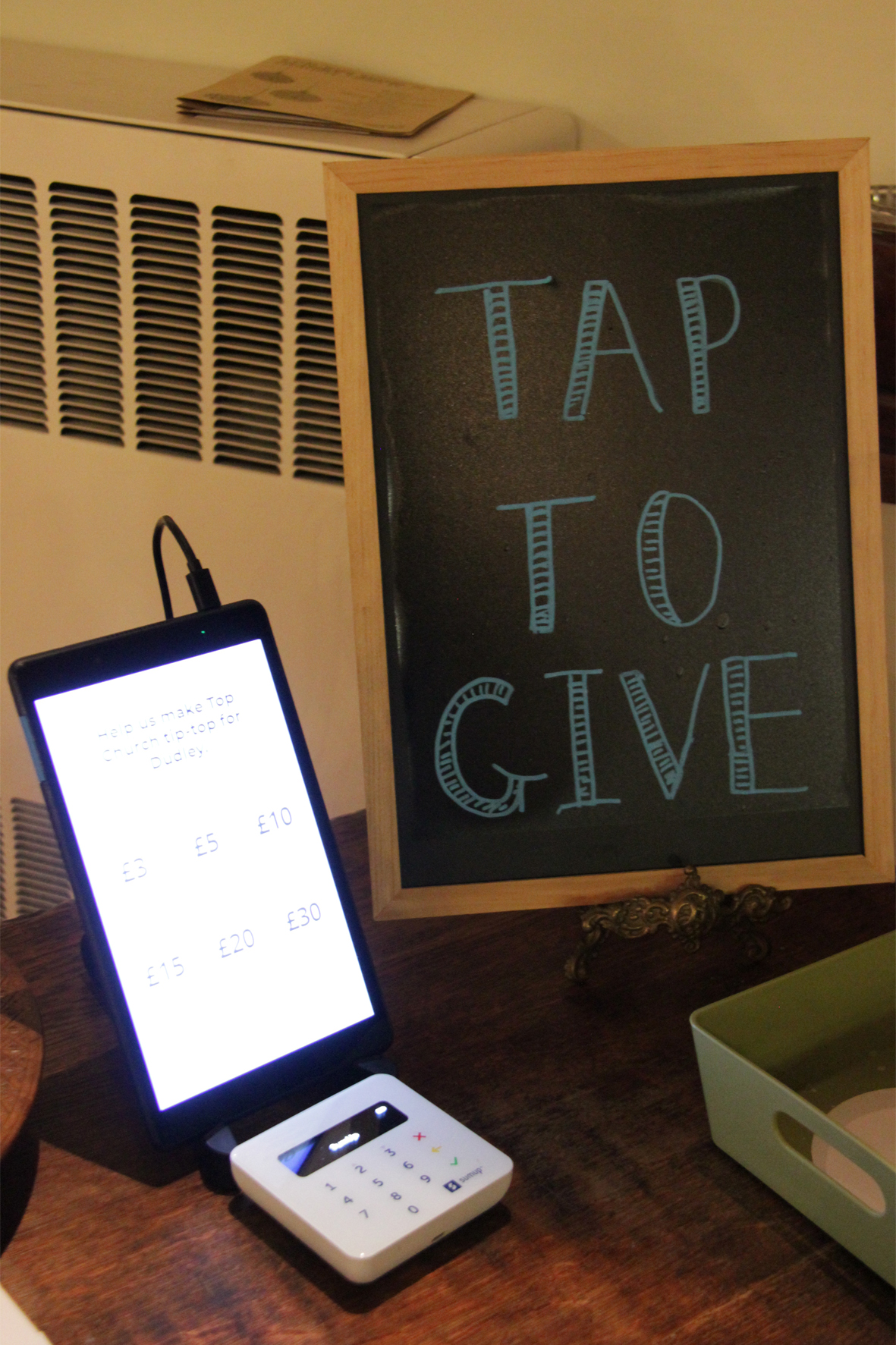 Sum up machine connected to an ipad with a 'tap to give' sign