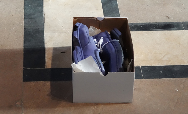Pair of battered shoes in a shoe box