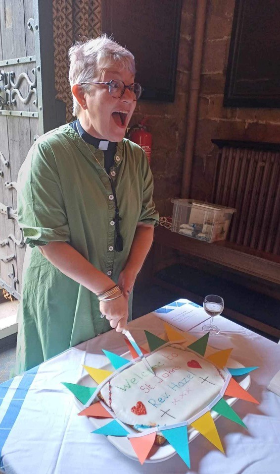 Hazel cutting a cake as she is welcomed to St john's church