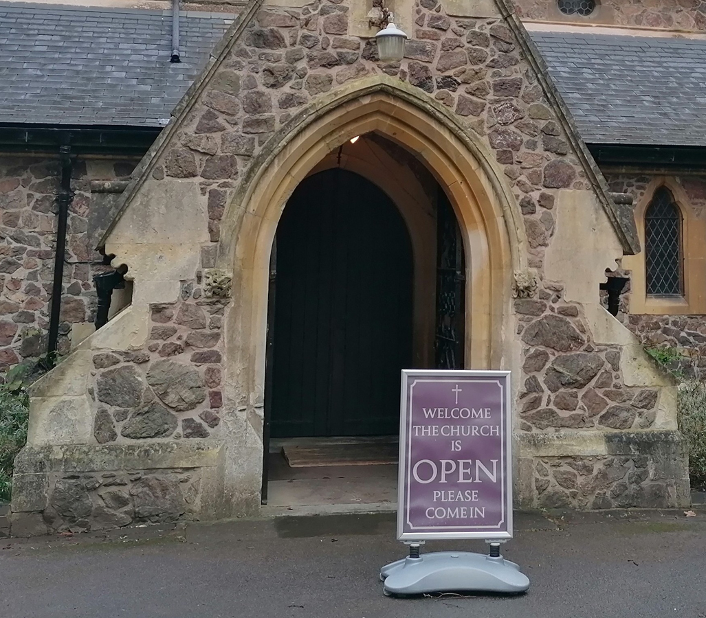 Church open sign outside an open church door