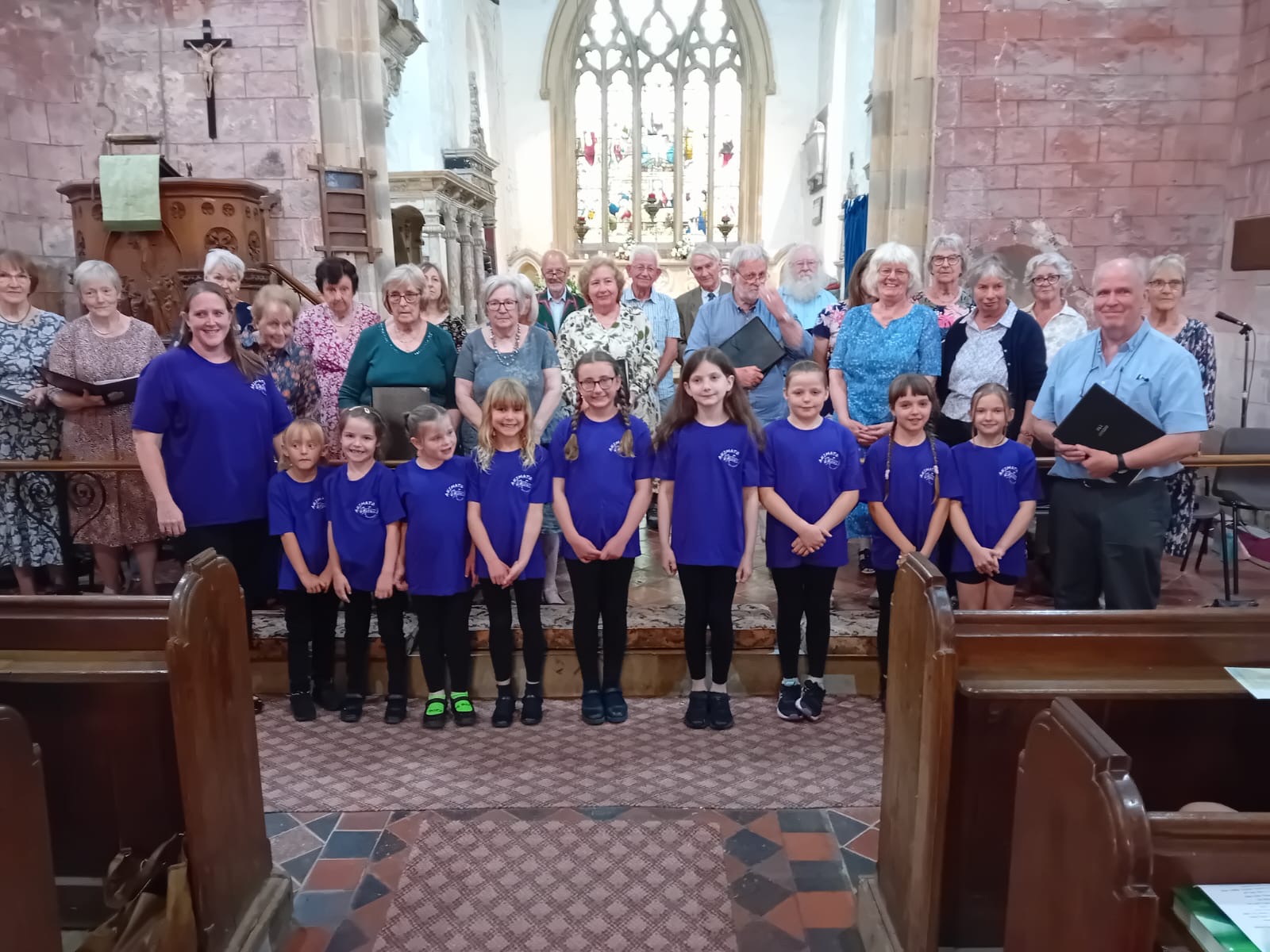 Animato choir standing with the Leigh singers at the front of Leigh church