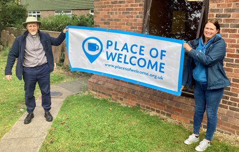 Carrie with a Place of Welcome banner