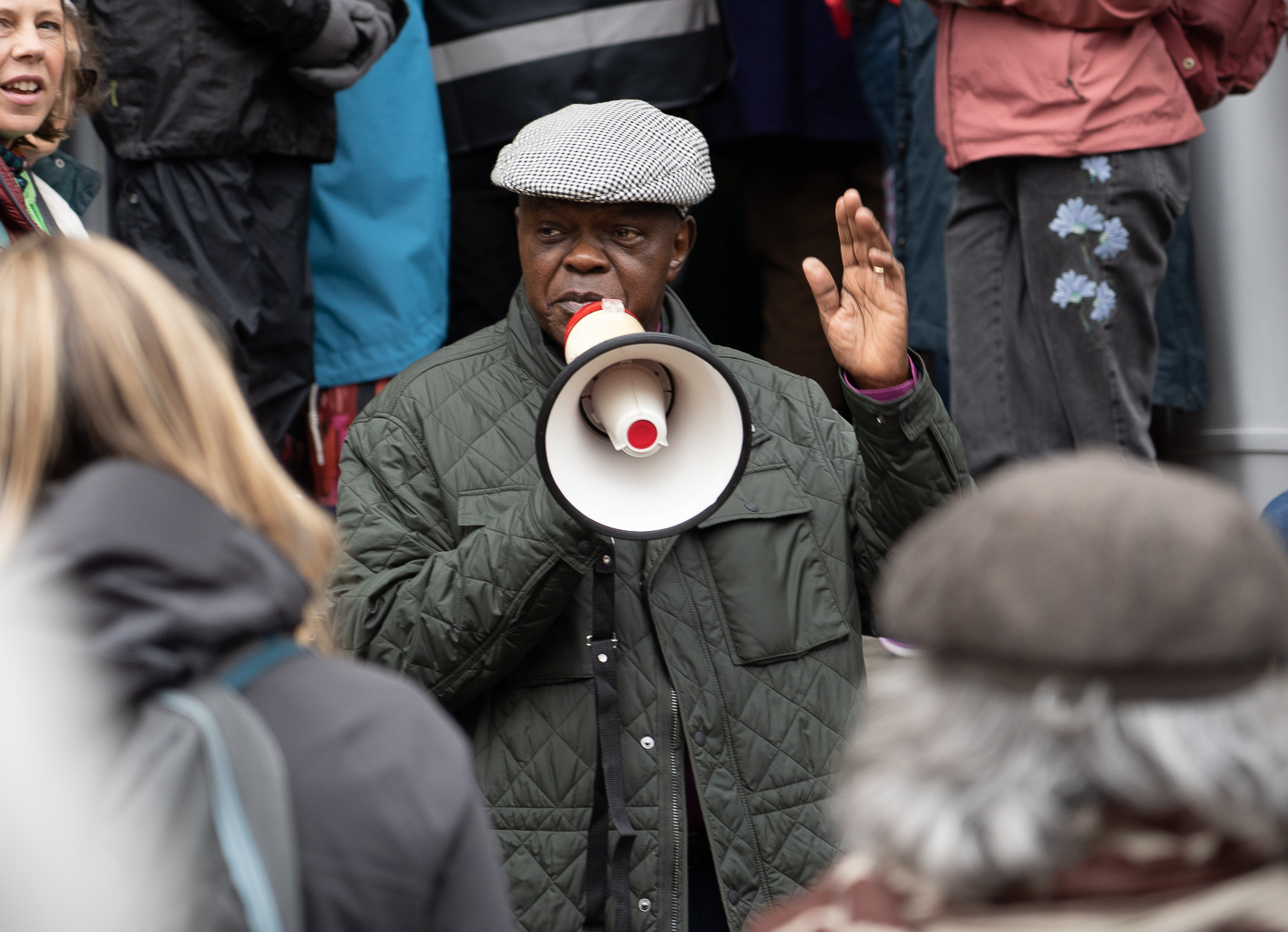 John Sentamu addresses the crowds holding a megaphone.